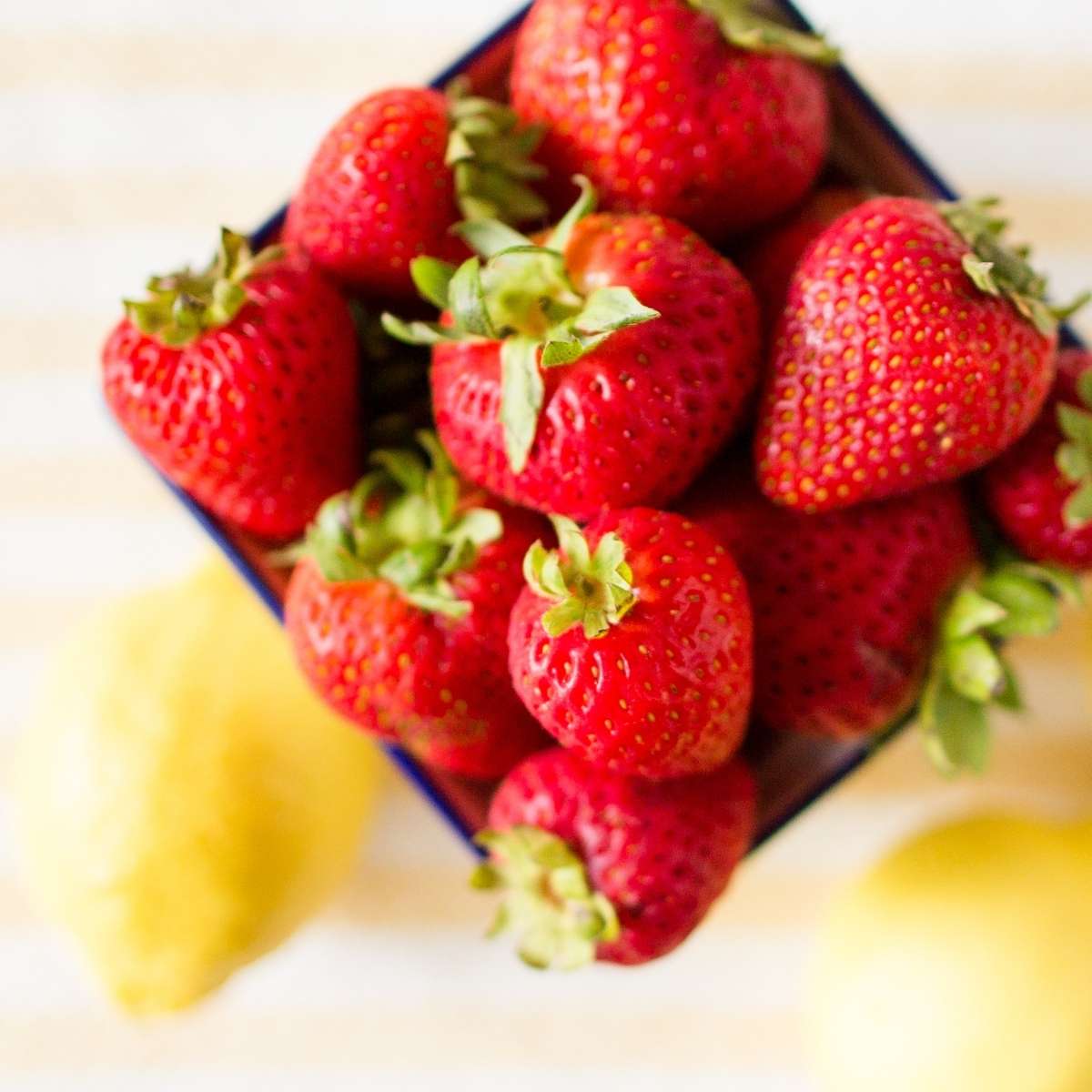 A pint of strawberries and lemons.