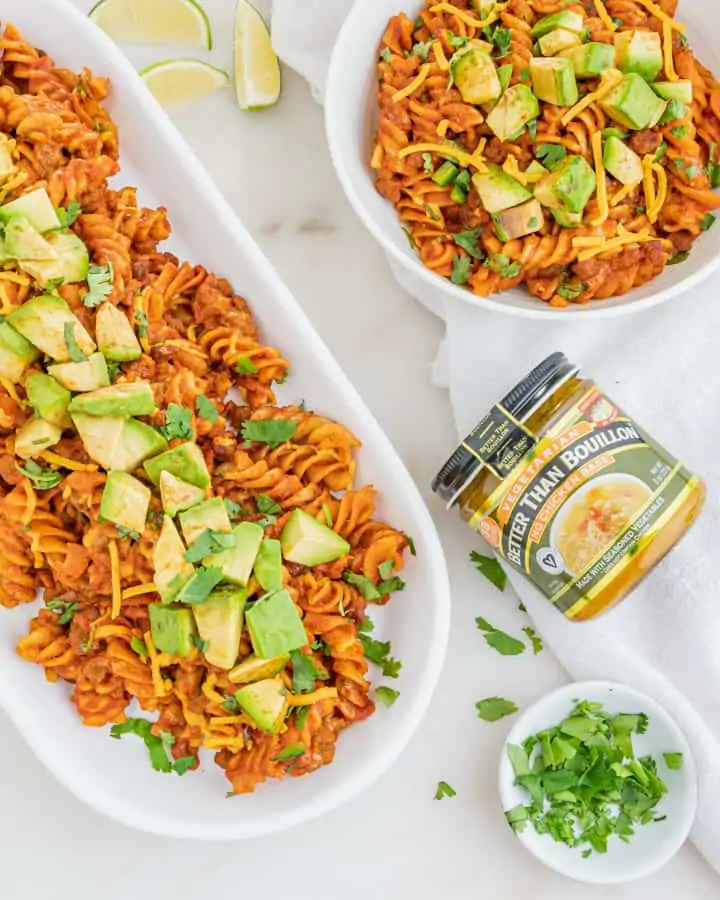 A platter of enchilada pasta next to a jar of Better Than Bouillon.