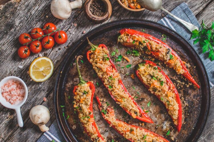 Couscous Stuffed Peppers served on a round serving dish with some ingredients on the side