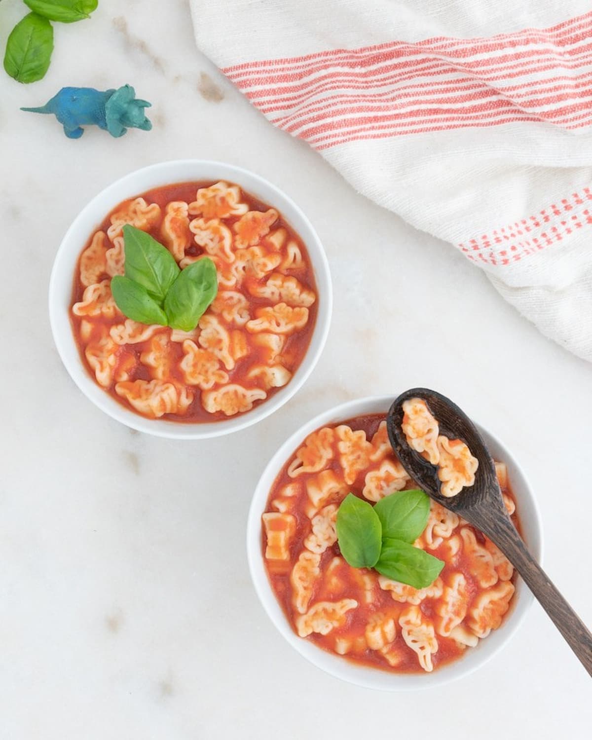 Two bowls of vegan SpaghettiOs, garnished with basil.