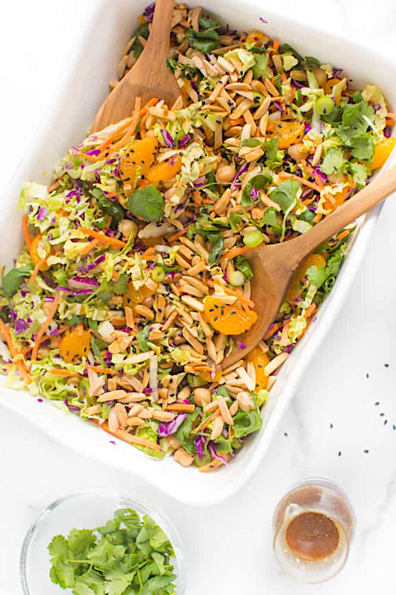 Vegan chinese chicken salad in a large serving dish with wooden serving spoons.