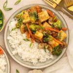 Vegan teriyaki stir fry served over jasmine rice with scallions and sesame seeds.