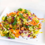 A plate of vegan chinese chicken salad with carrots, cabbage and chickpeas.
