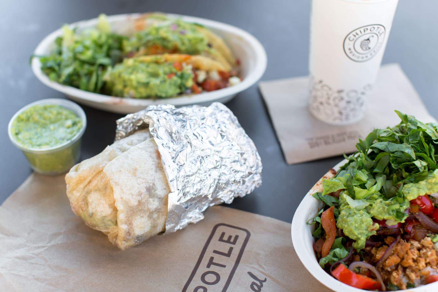 Vegan Chipotle Burrito Tacos and Burrito Bowl and a Side of Guacamole on a Table