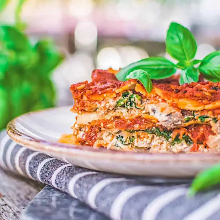 Vegan Lasagna with Tofu Ricotta and Marinara Sauce on a plate topped with basil.