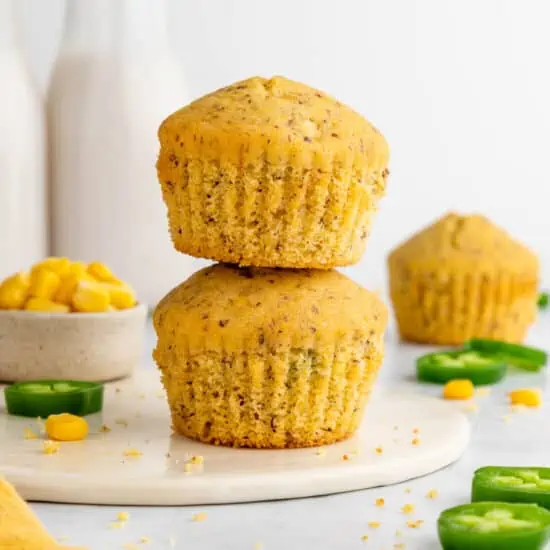 Vegan cornbread muffins stacked on a plate.
