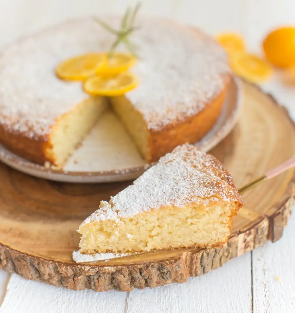 vegan lemon olive oil cake on a plate on top of a tree ring