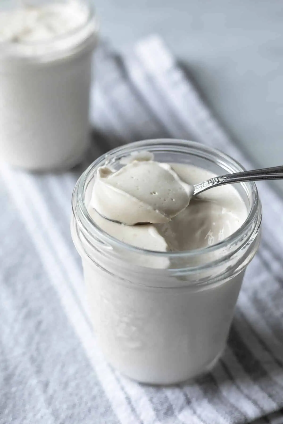 A glass jar filled with almond milk yogurt.