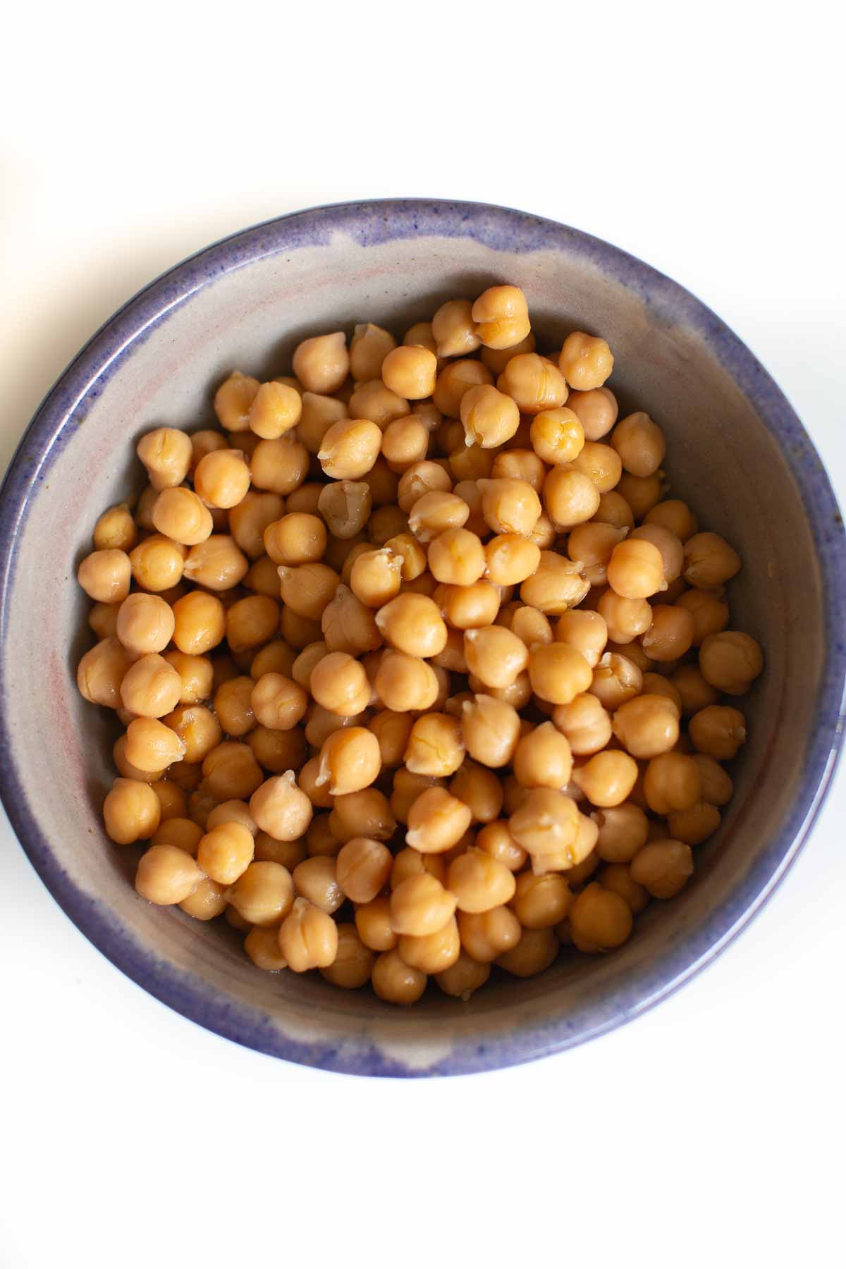 A pottery bowl filled with chickpeas that have been drained, rinsed, and dried.