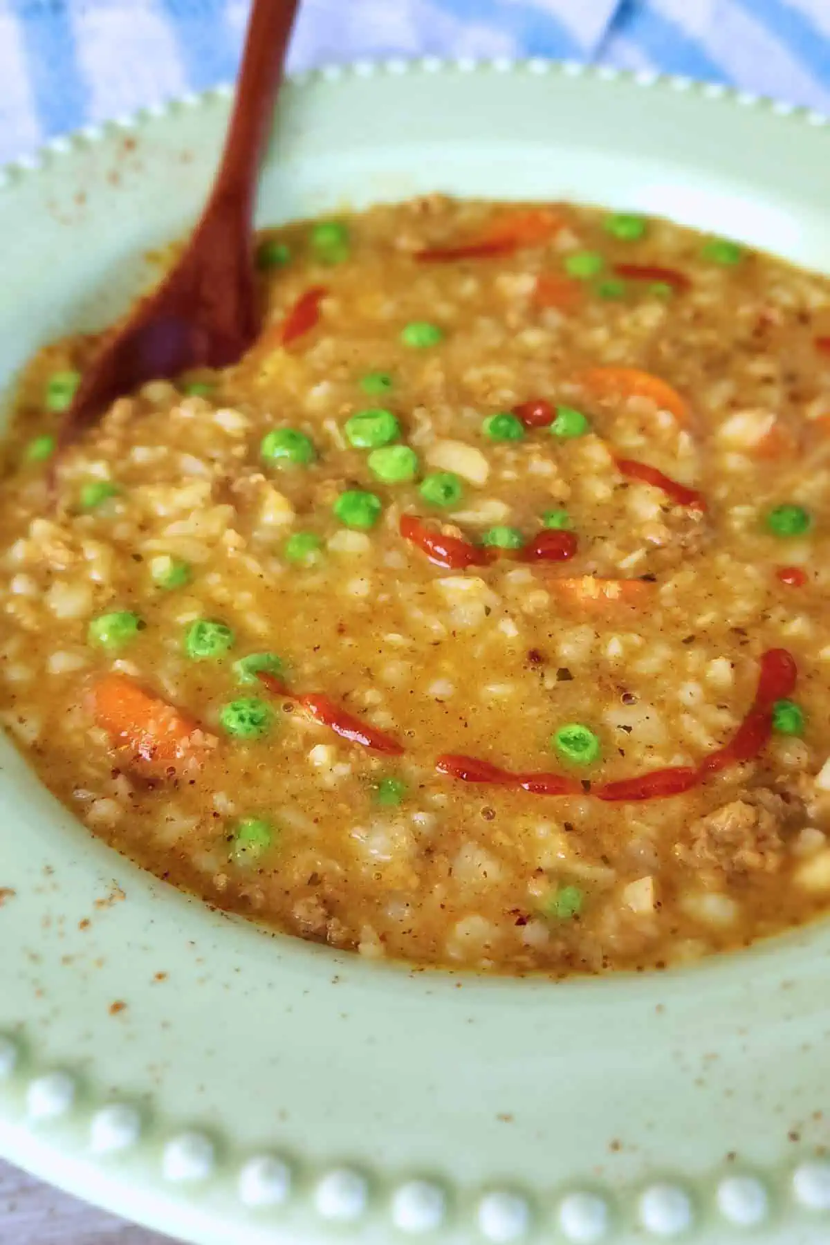 Large bowl of instant pot vegan stew topped with hot sauce and served with a spoon.