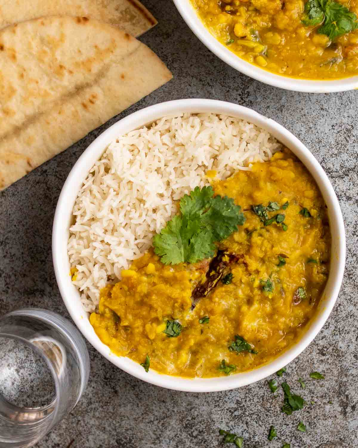 A bowl filled with half rice and half moong masoor dal, topped with fresh cilantro.