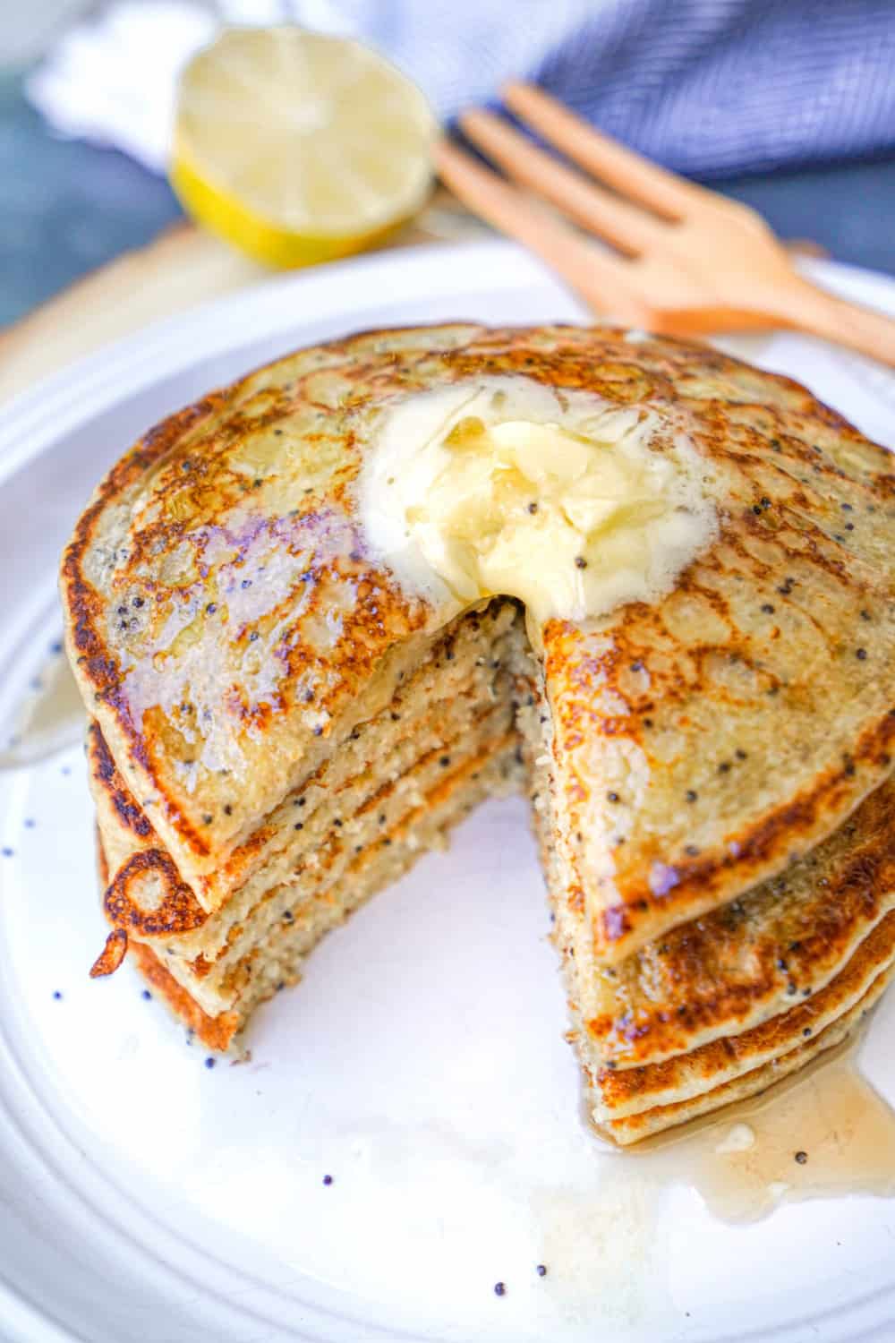 Vegan Lemon Poppyseed Pancakes Stacked with Syrup and Butter