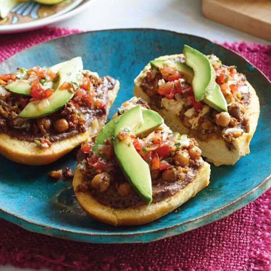 Vegan mollete made with chickpea chorizo and topped with avocado slices and salsa.