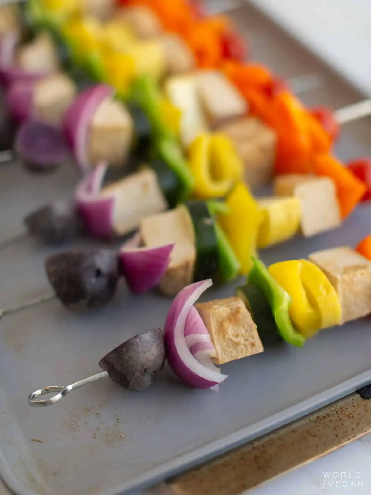 Assembled tofu kebabs on a cooking tray.