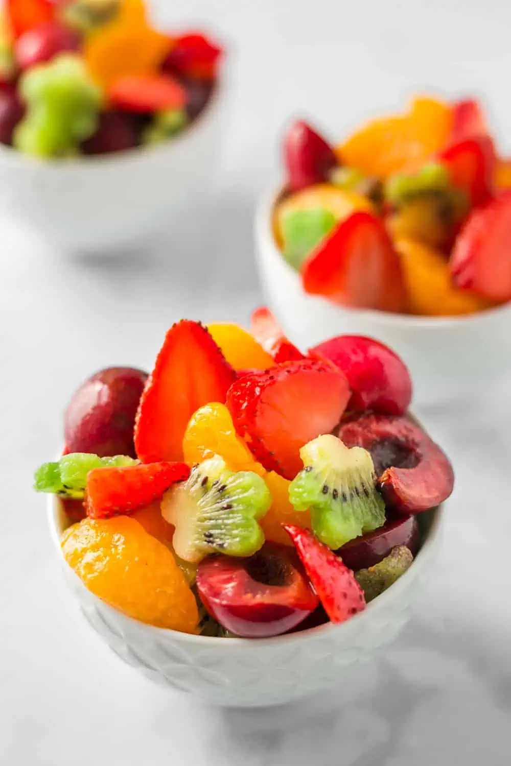Three small serving bowls filled with sweet fruit tart salad.
