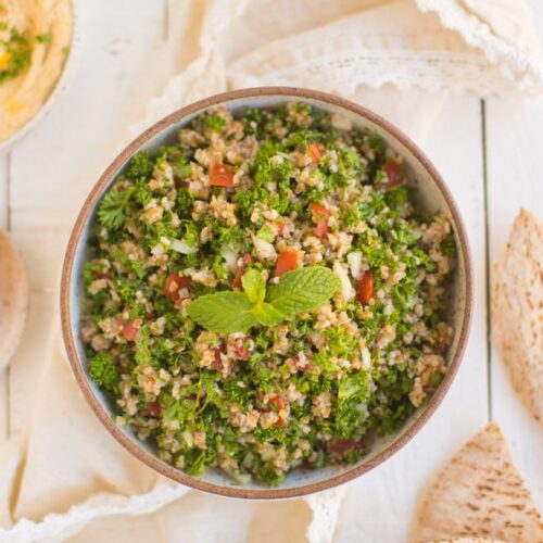 Tabbouleh salad served in a dish with pita and hummus