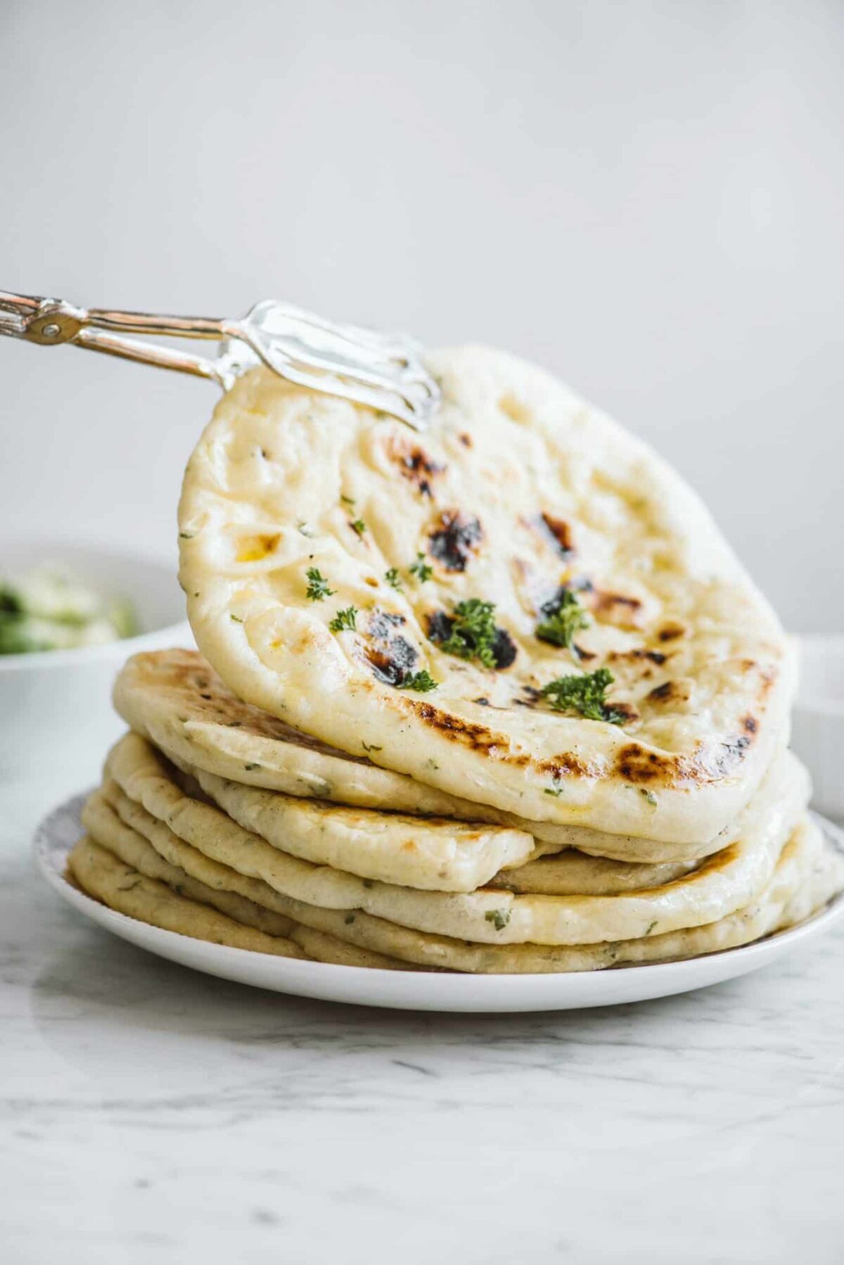 A stack of fresh homemade pita bread on a plate.