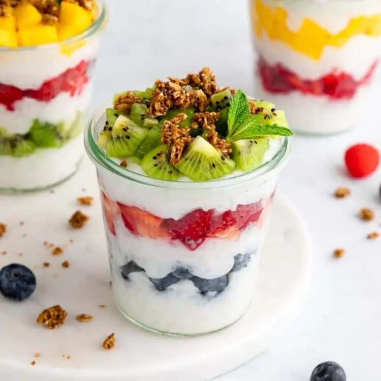 Vegan breakfast parfait made with tapioca, chia, or rice pudding layered with fresh fruit and granola in a mason jar.