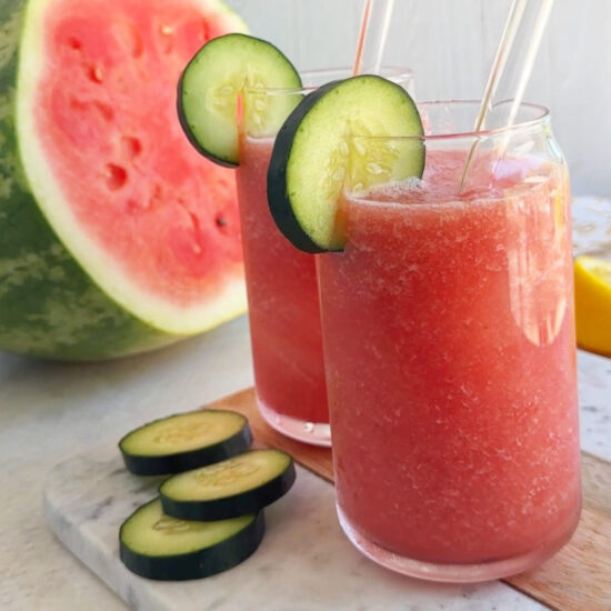 Two glasses of watermelon cucumber drink agua fresca served on a table.