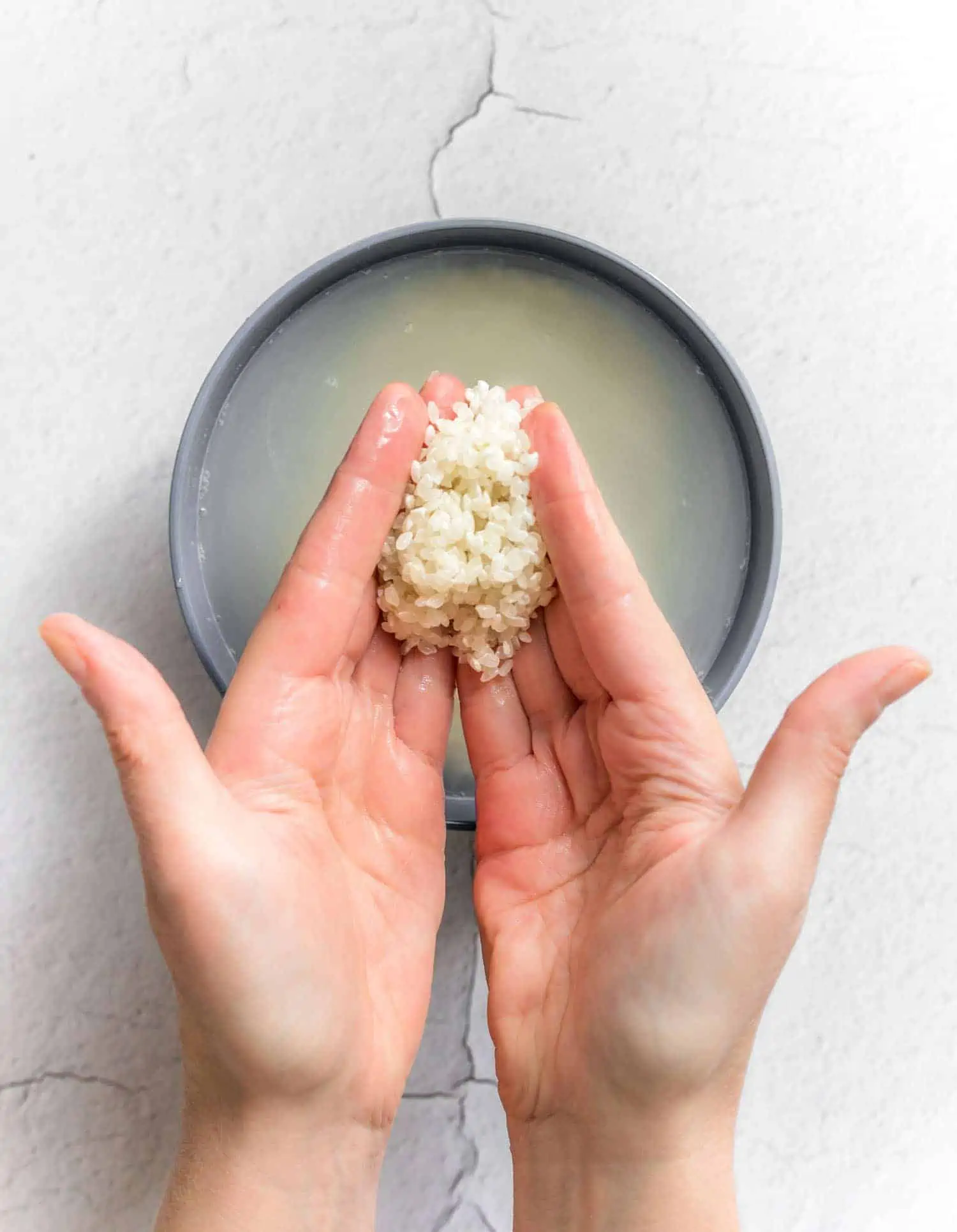 Rinsing sticky rice in a bowl.