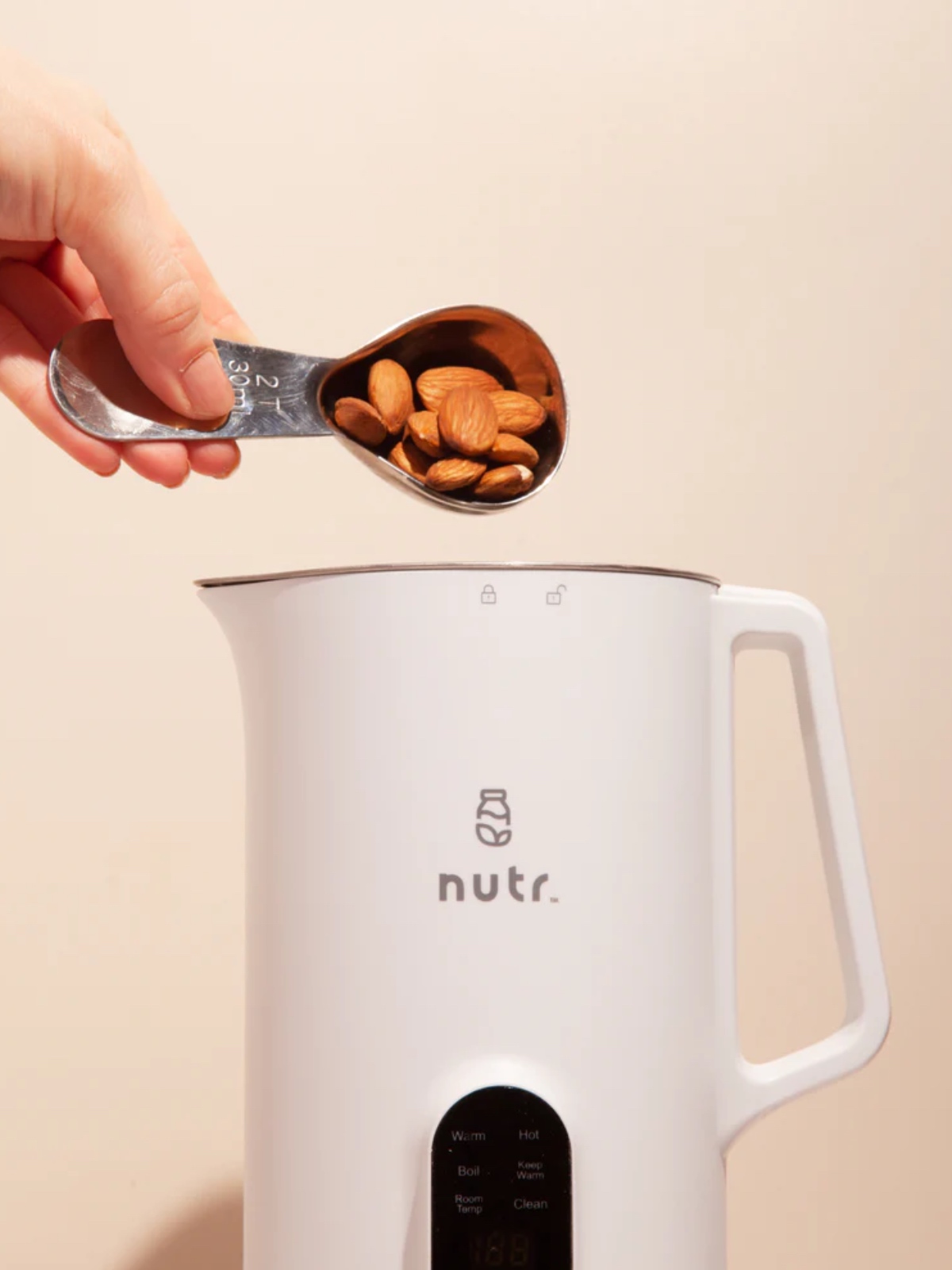 Pouring almonds into the Nutr nut milk maker machine. 