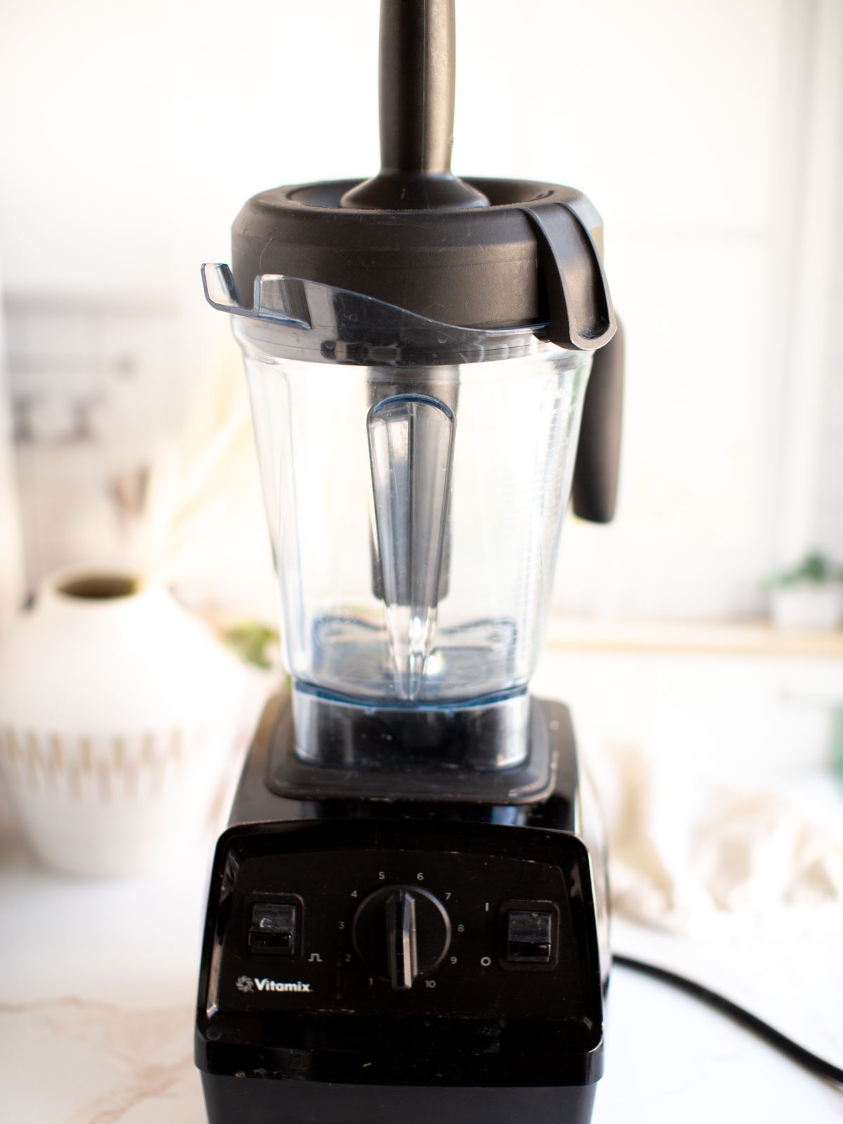 An empty Vitamix blender on a kitchen table. 