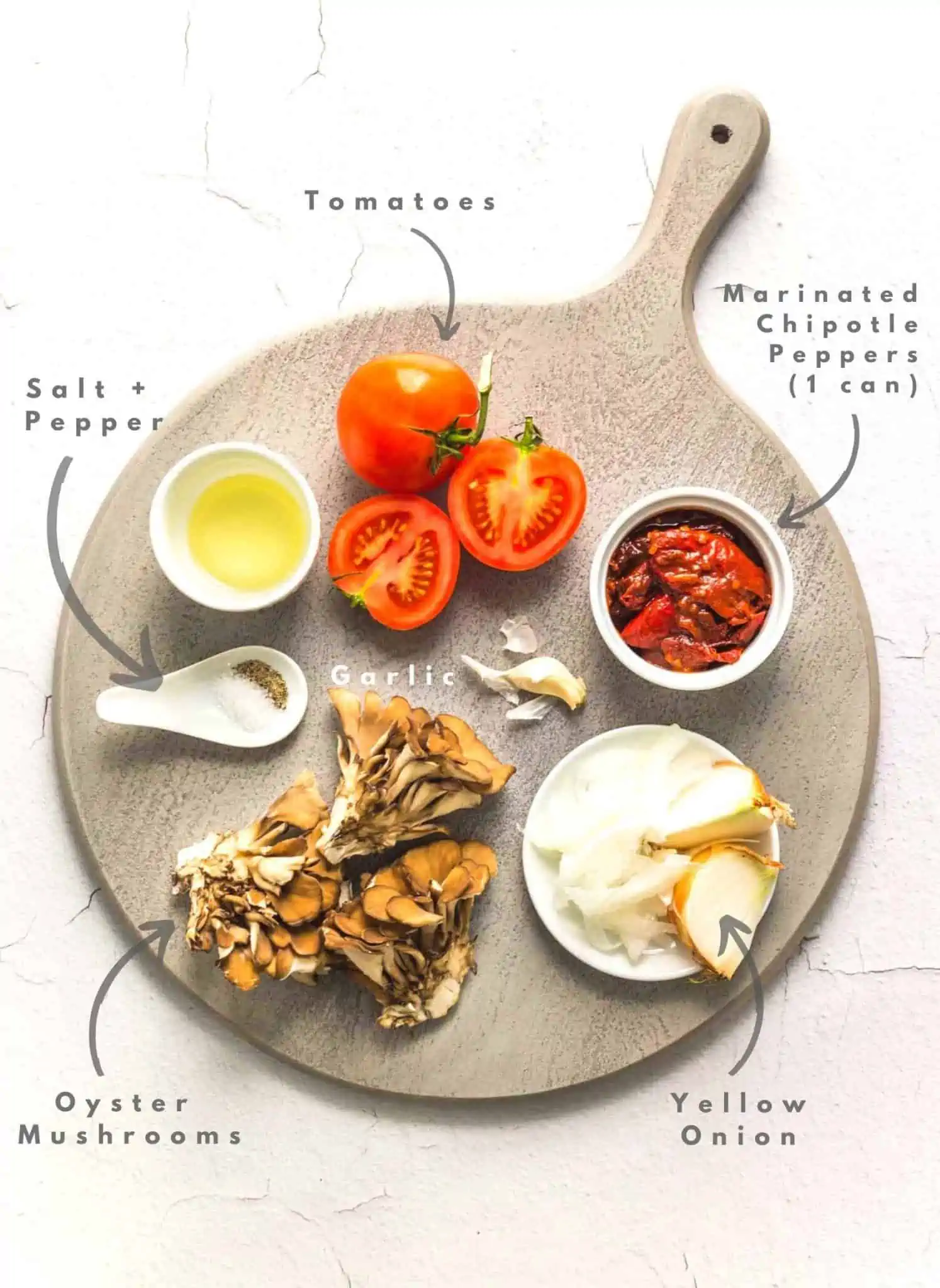 Chipotle pulled oyster mushroom taco ingredients labeled on a cutting board.