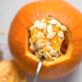 spoon scooping seeds out of pumpkin