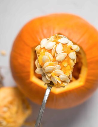 spoon scooping seeds out of pumpkin