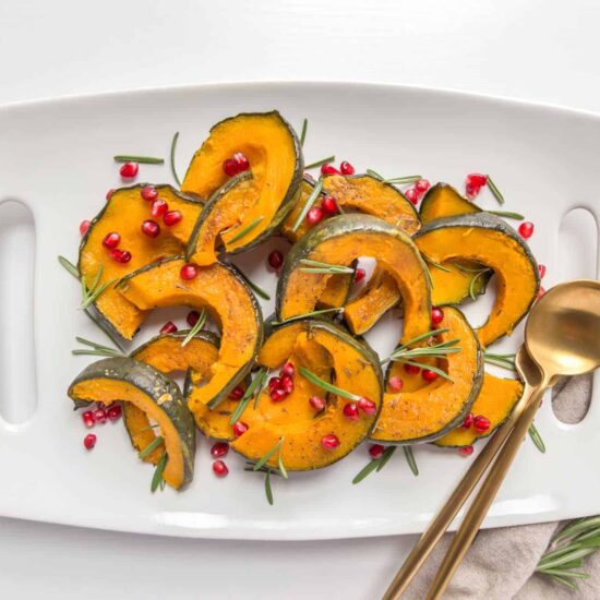 Air Fryer Kabocha Squash With Pomegranite Seeds On A White Plate Vegan Thanksgiving Recipe