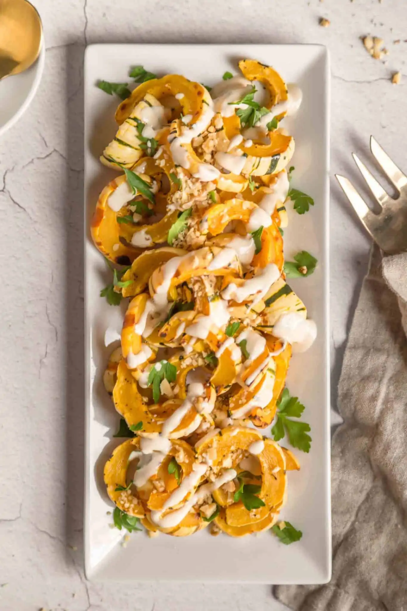 Roasted Delicata Squash garnished on a plate.