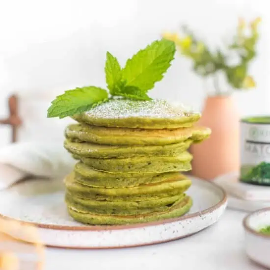 Green Vegan Matcha Pancakes Recipe Stacked on a Rustic Plate