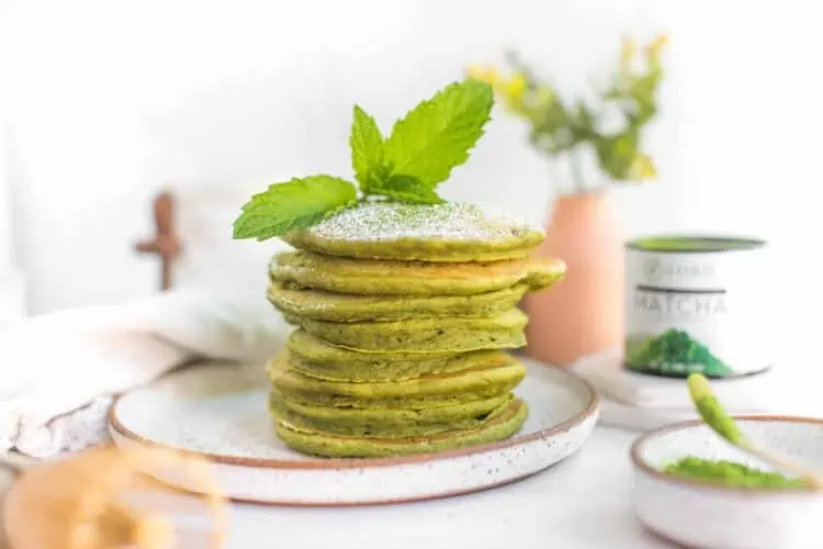 Green Vegan Matcha Pancakes Recipe Stacked on a Rustic Plate