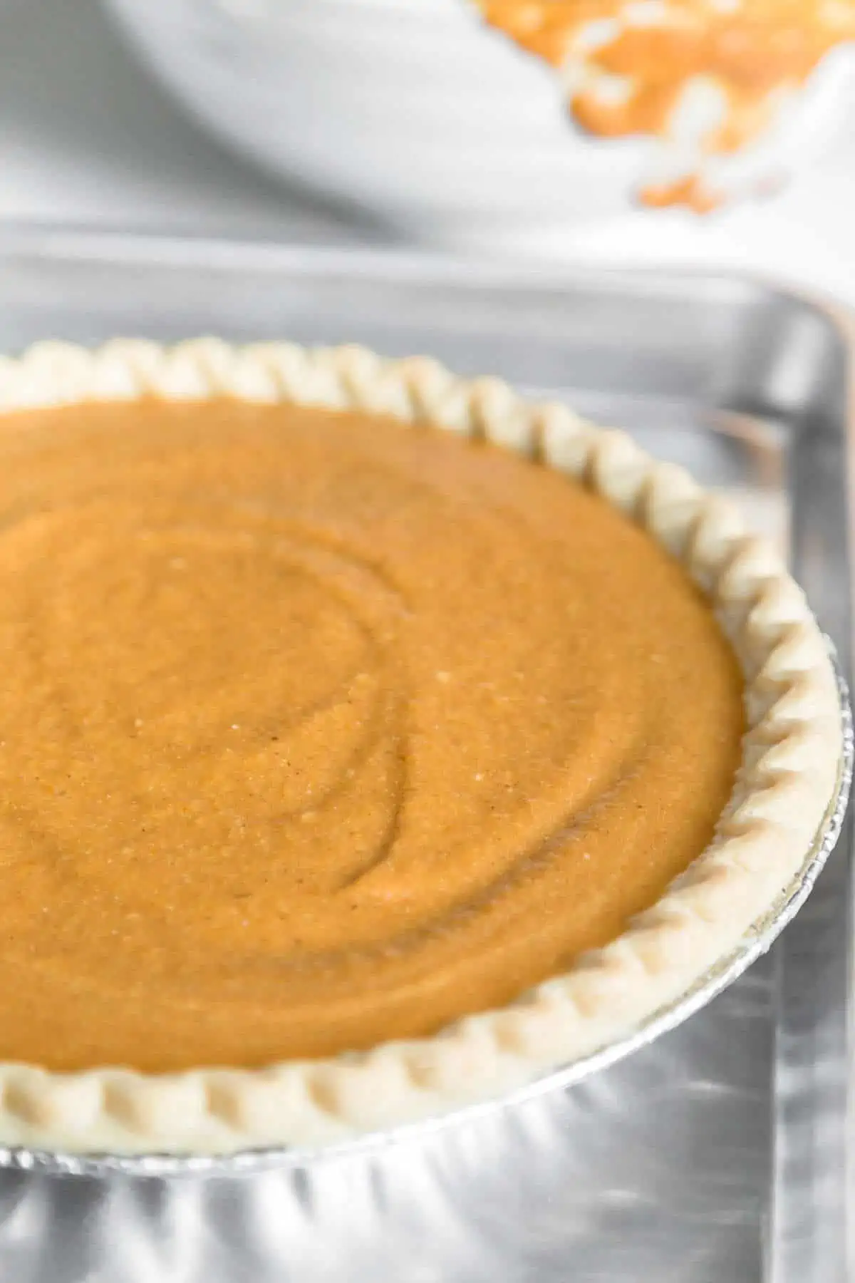 Vegan pumpkin pie filling mixed and poured into the prepared pie crust.