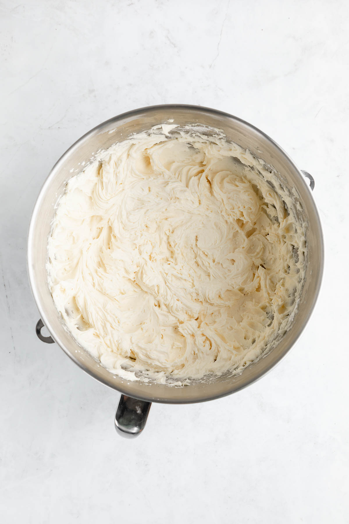 A big mixing bowl filled with vanilla vegan frosting. 