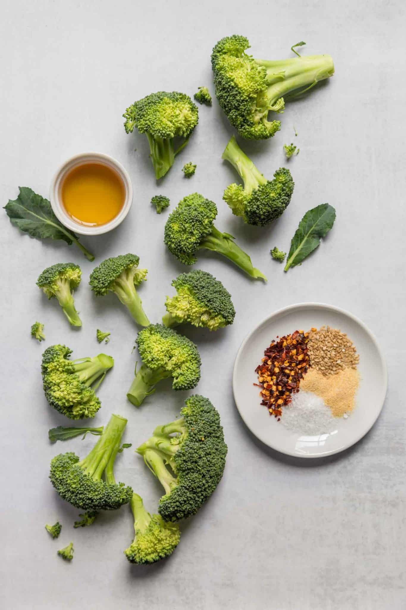 broccoli florets cut up on a cutting board with spices for air fryer broccoli