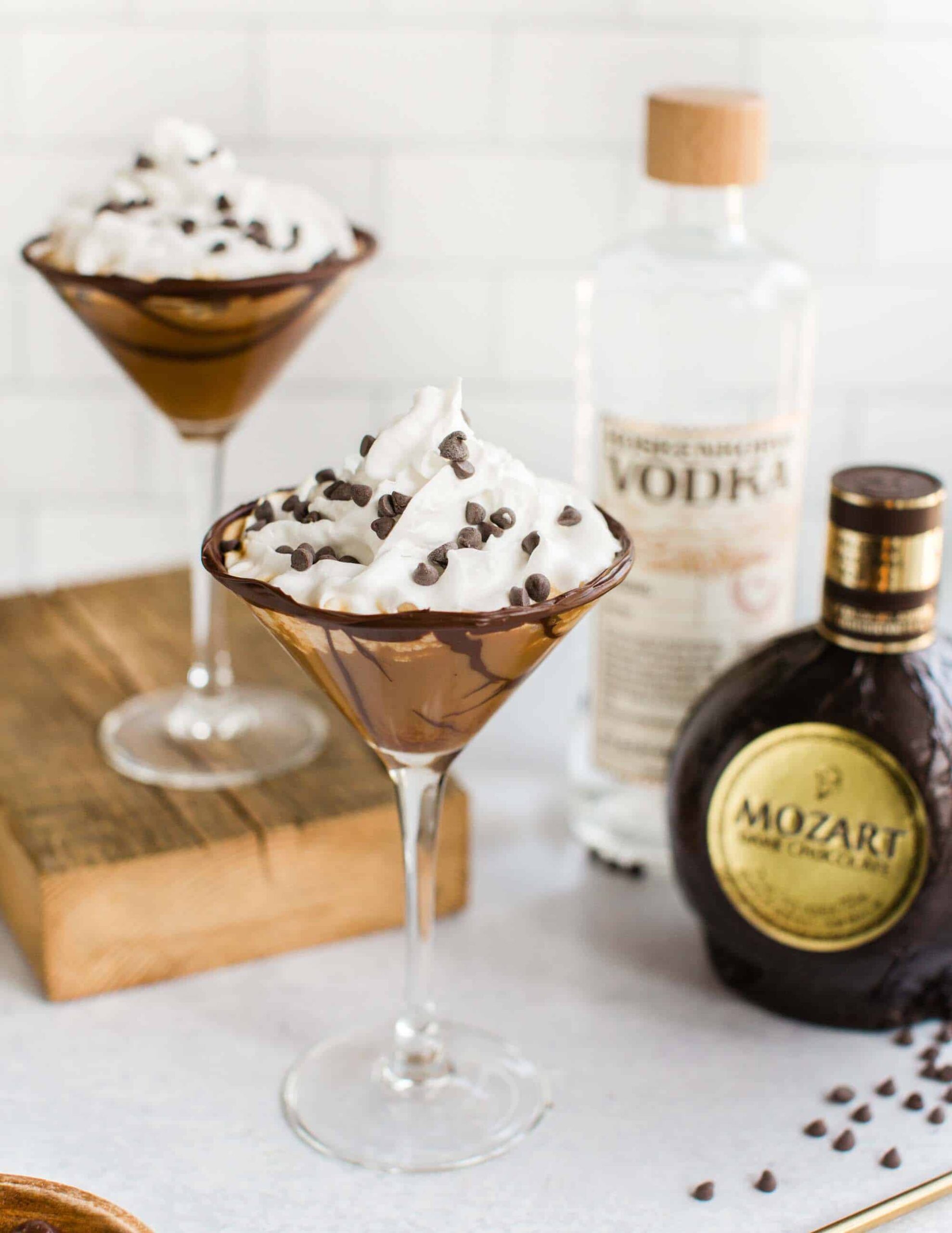 vegan chocolate martinis with vegan whipped cream and chocolate chips alongside Mozart liqueur
