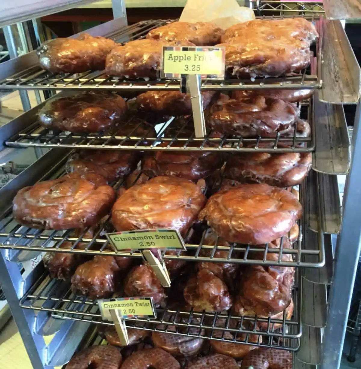 rack of fresh baked raised vegan donuts and apple fritters