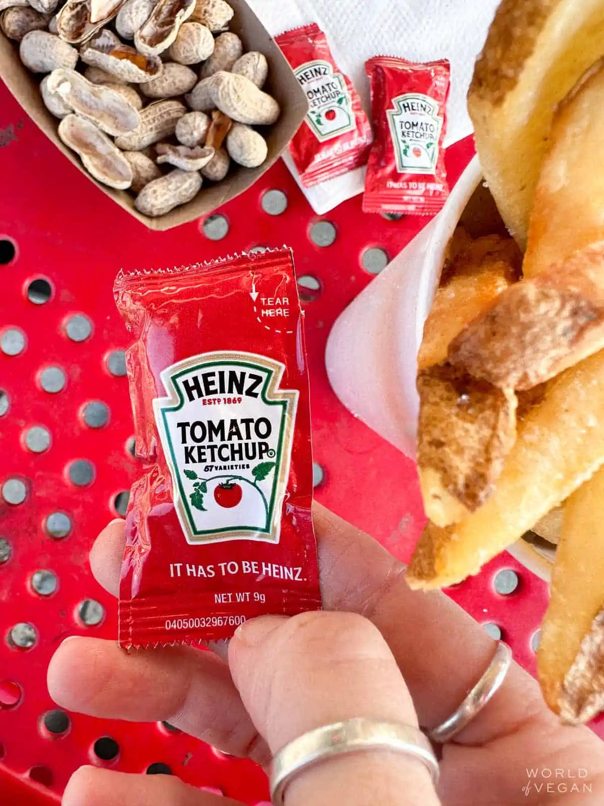 Holding a Heinz ketchup packet near Five Guys fries.