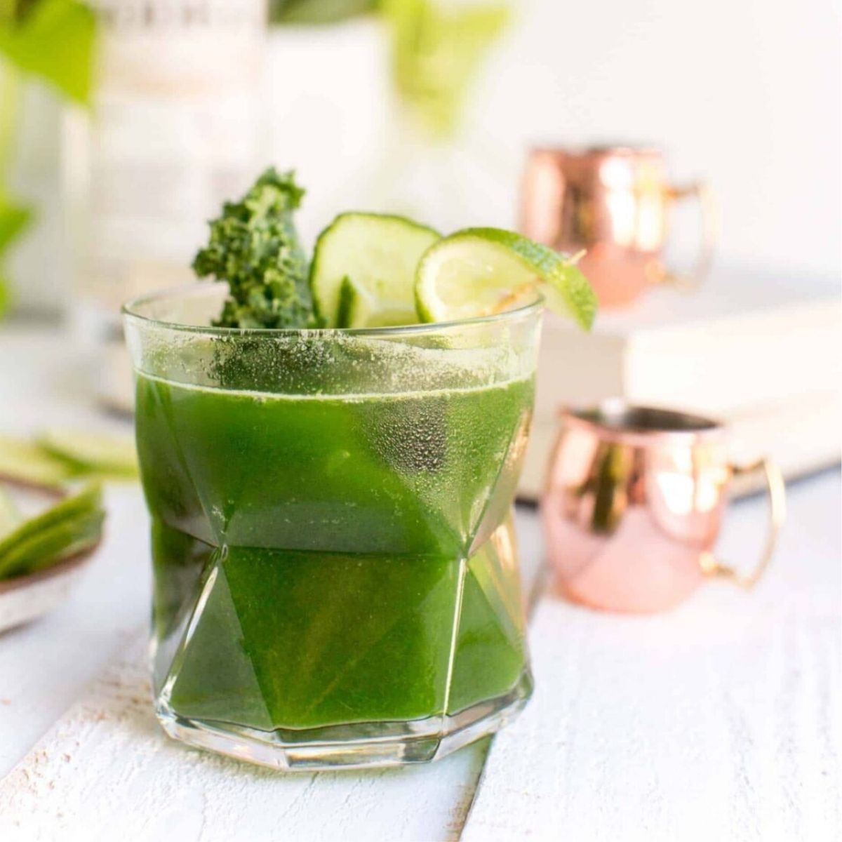 A kale cocktail in a glass with a lime garnish.