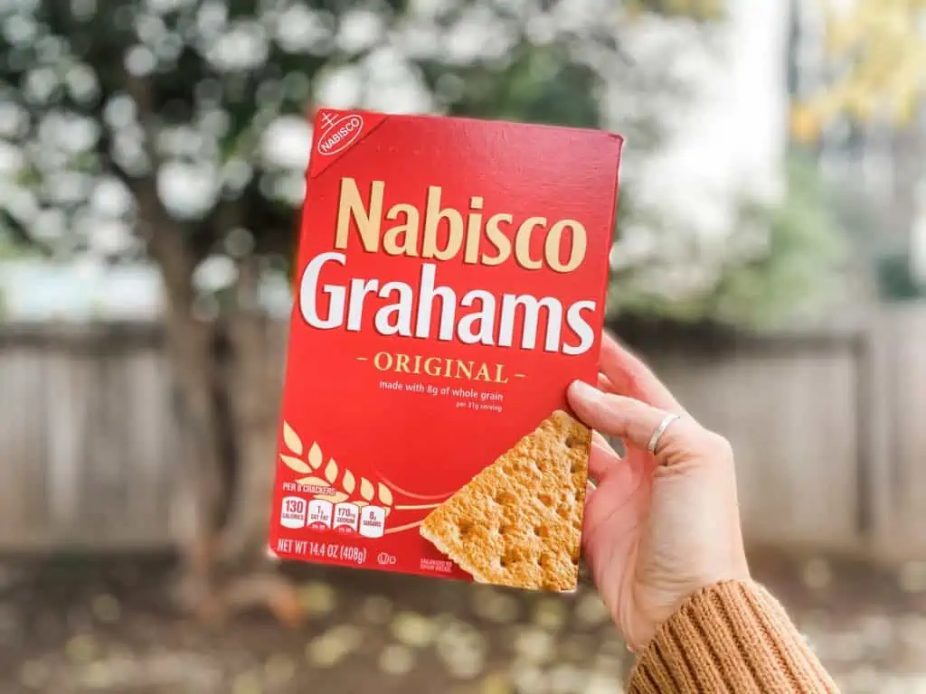 Holding up a red box of original Nabisco Grahams made with whole grain ingredients that are accidentally vegan