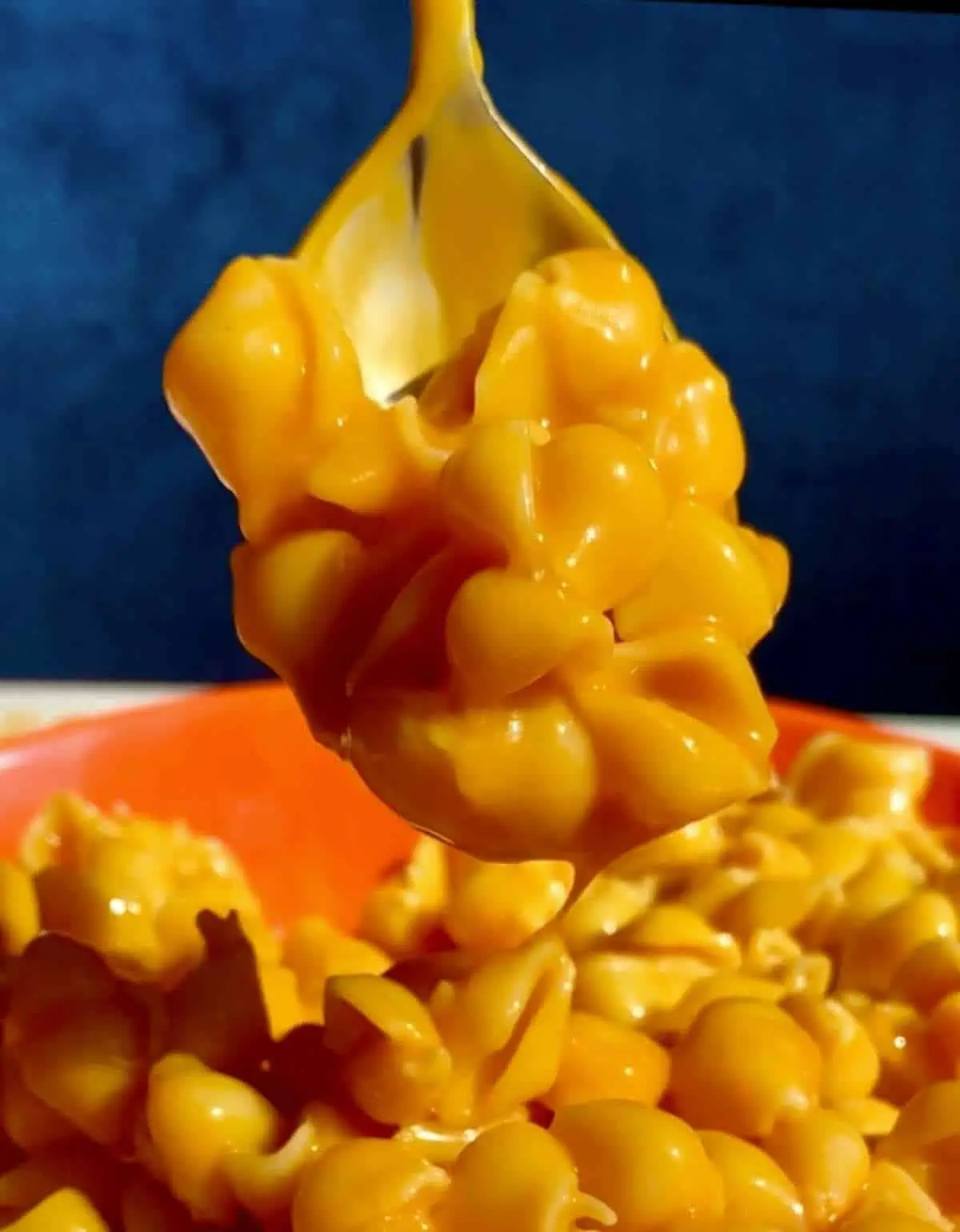 A spoon scooping up a bite of Banza's Vegan Deluxe Mac and Cheese.