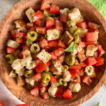 Italian tomato salad served in a large wooden bowl.