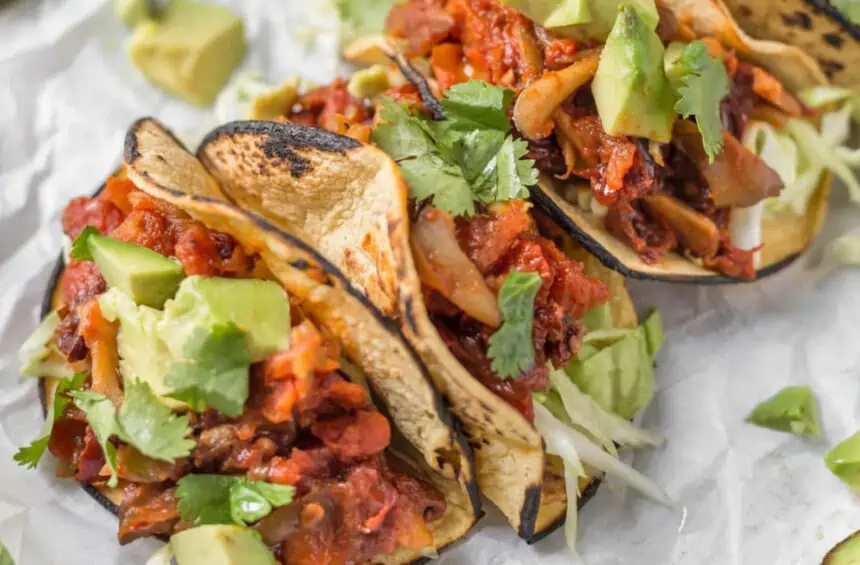 Vegan Mushroom Tacos with avocado and lemon wedges.