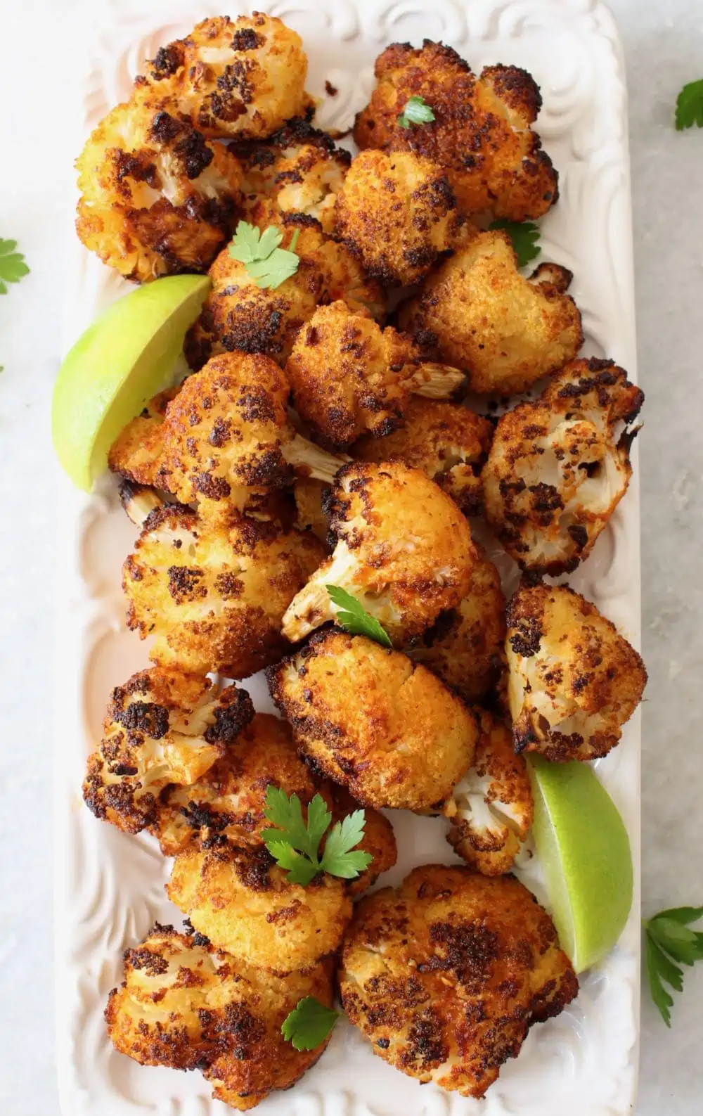 plate of air fried cauliflower wings garnished with lime wedges