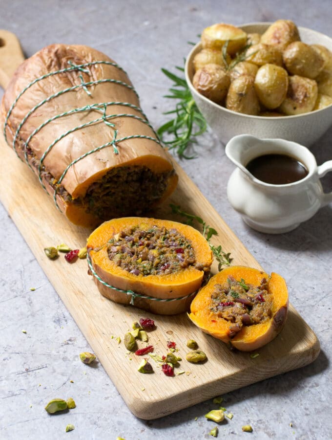 butternut squash roast stuffed with lentil stuffing on a cutting board