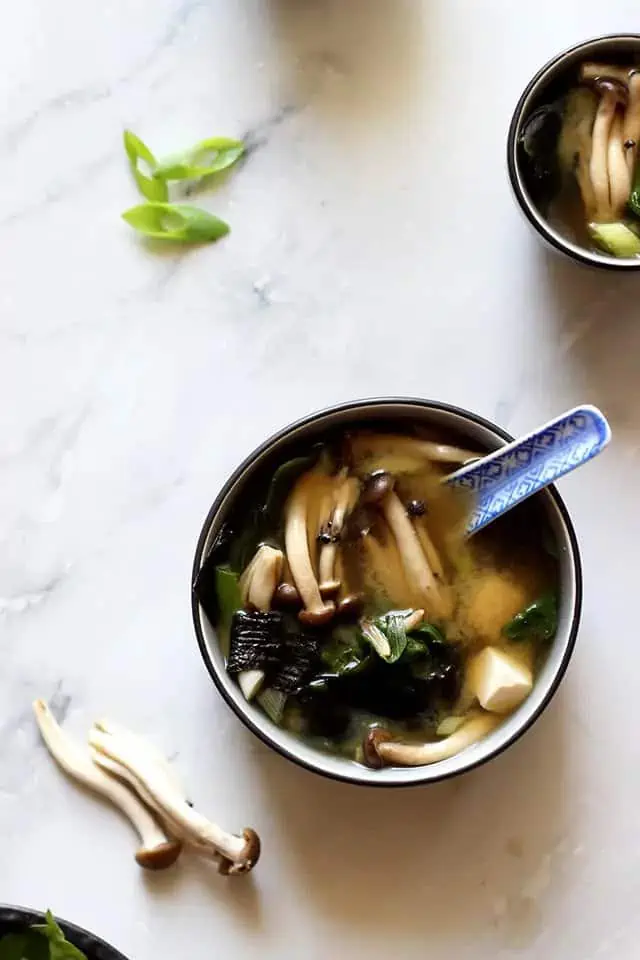 miso soup in a bowl with mushrooms, tofu, and seaweed