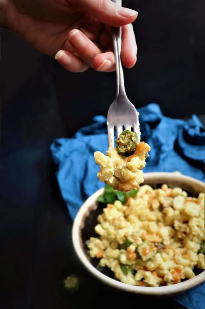 fork full of okra mac and cheese with bowl in the background