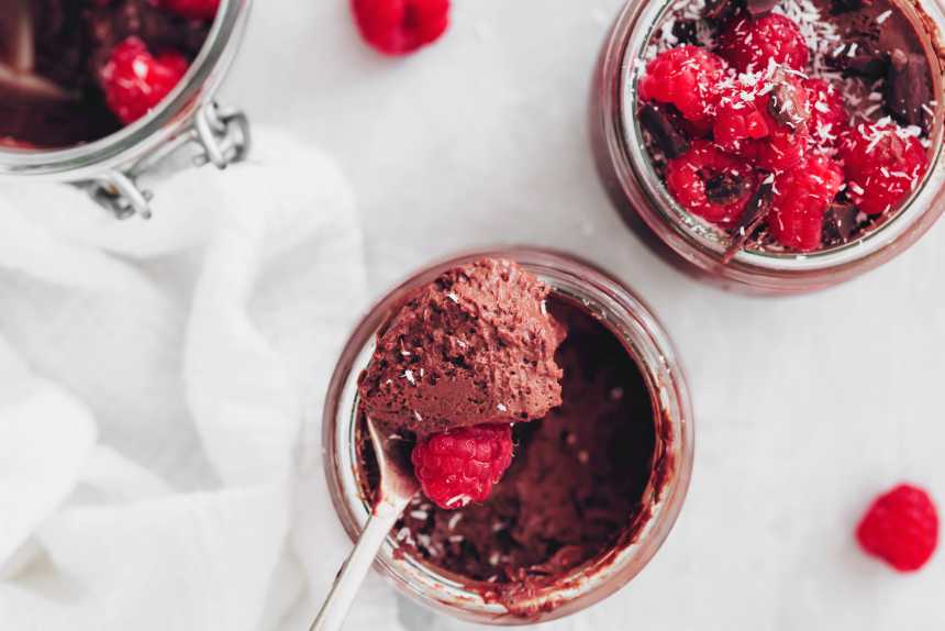 vegan chocolate mousse in glass jars with raspberries