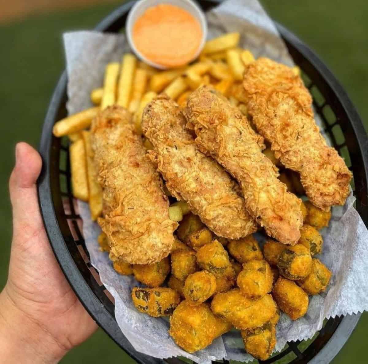 A plate of vegan fried chicken, fried okra, and fries.